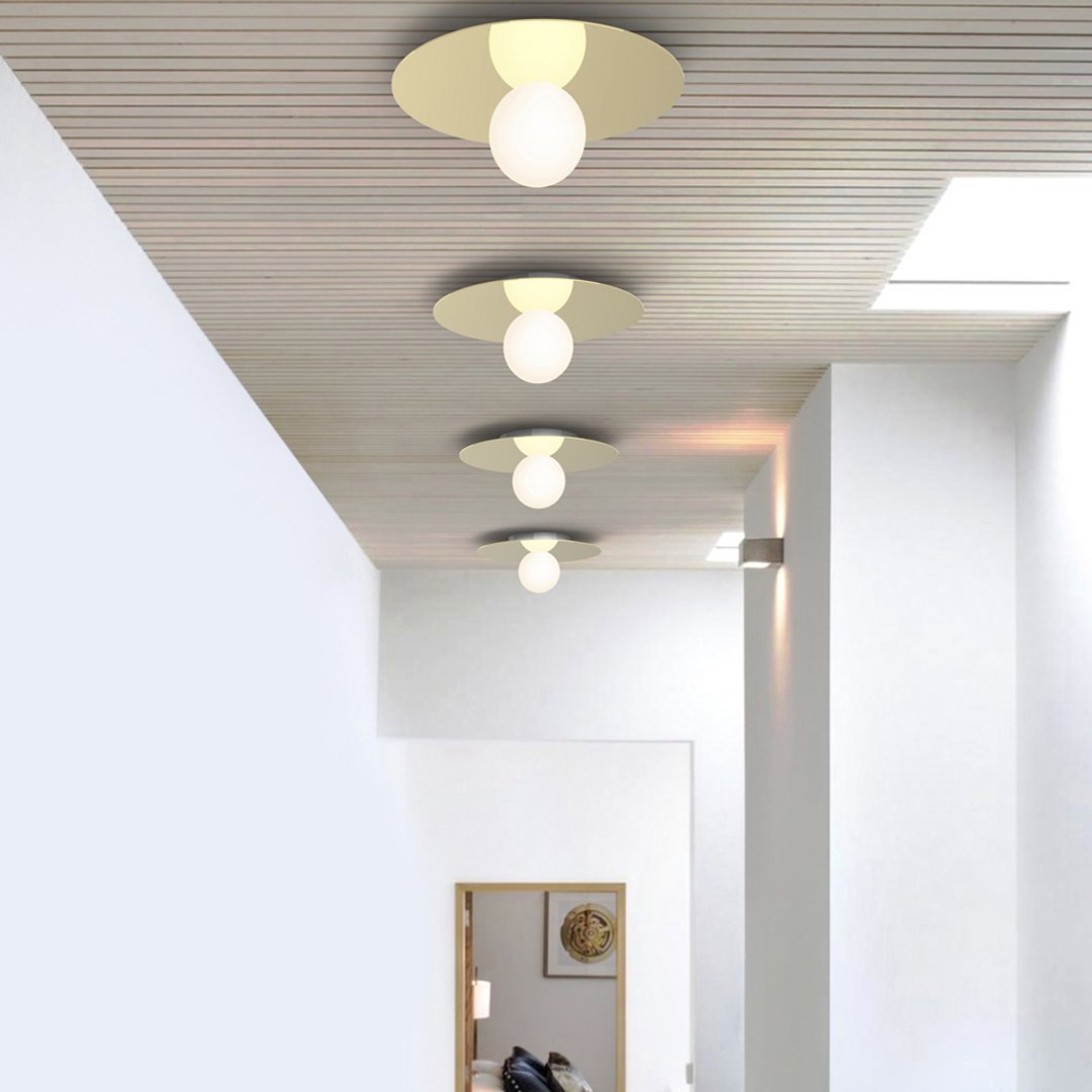 Modern ceiling lights in gold and white, featuring round shades and sleek, minimalist design.