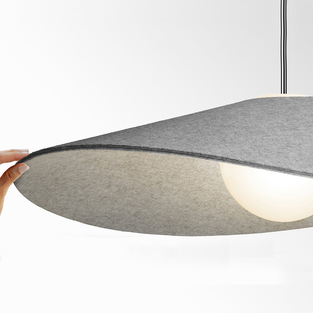 Gray felt pendant lamp shade with a soft, rounded design and warm interior glow. Ideal for modern interiors.