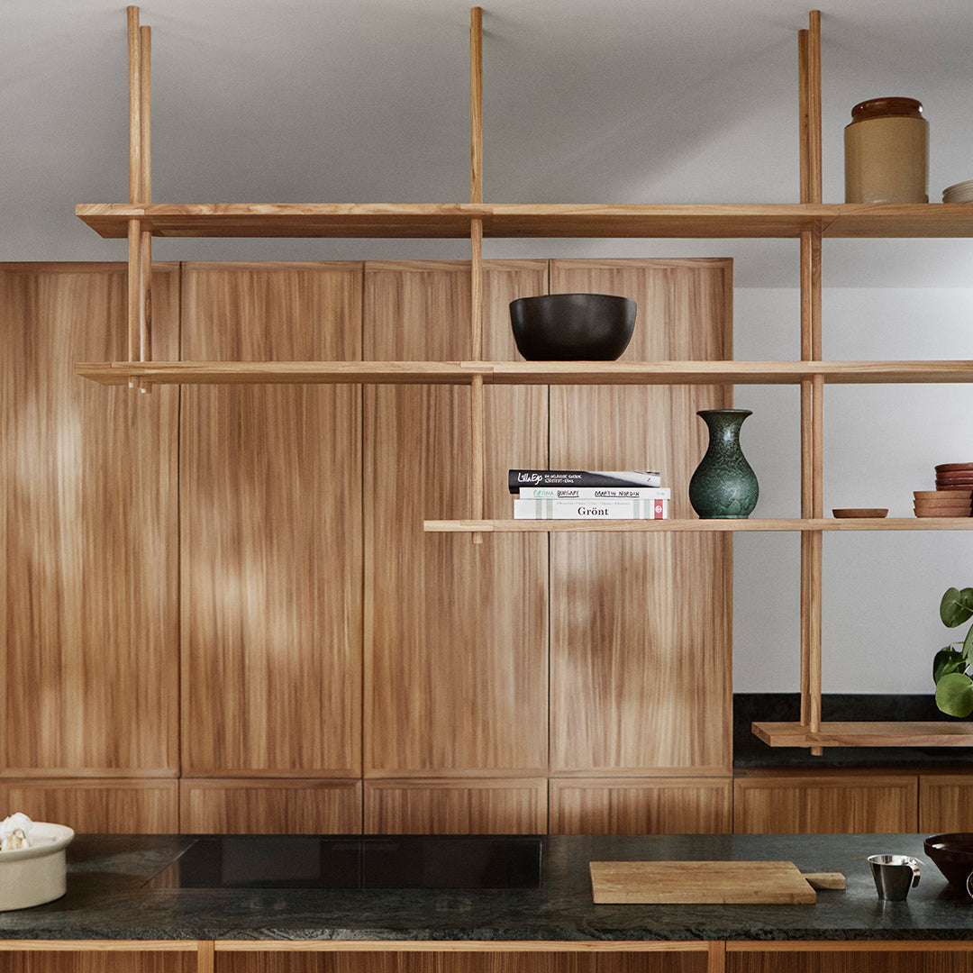 Wooden shelves in a warm, natural finish against a sleek black countertop, featuring simple, modern decor elements.