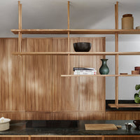 Wooden shelves in a warm, natural finish against a sleek black countertop, featuring simple, modern decor elements.