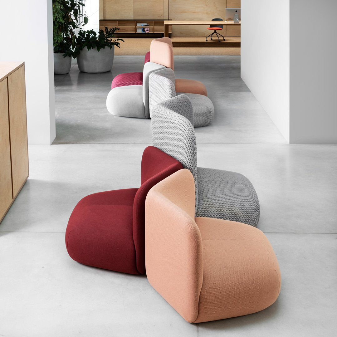"Modern modular chairs in burgundy, gray, peach, and blush, featuring sleek, curved designs and soft textures."