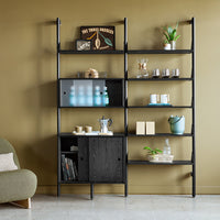 Black shelving unit against olive green wall, featuring clear and muted accents with natural wood and metallic elements.