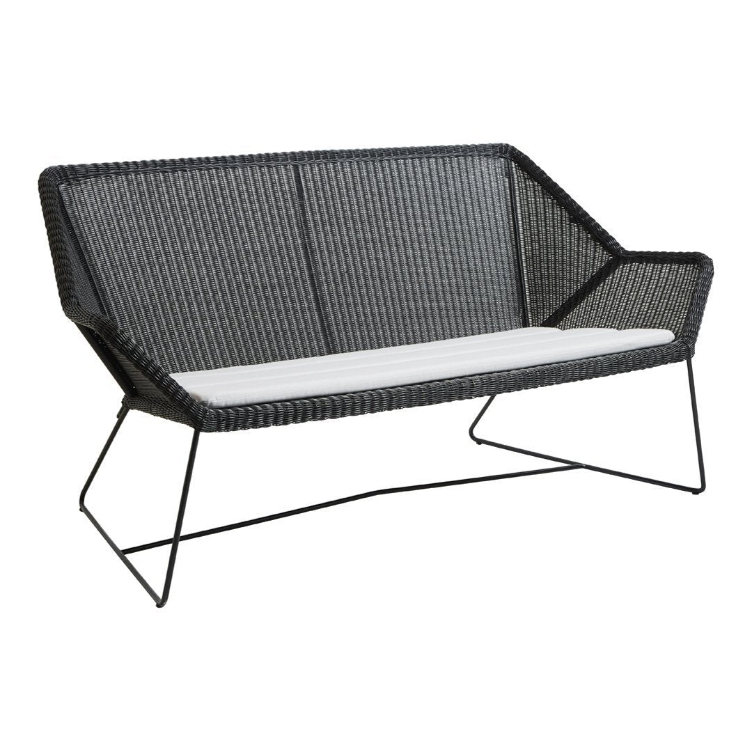 Black woven outdoor loveseat with a white cushion, featuring a modern geometric design.