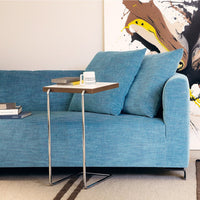 Light blue textured couch with two matching cushions, complemented by a sleek side table and modern artwork.