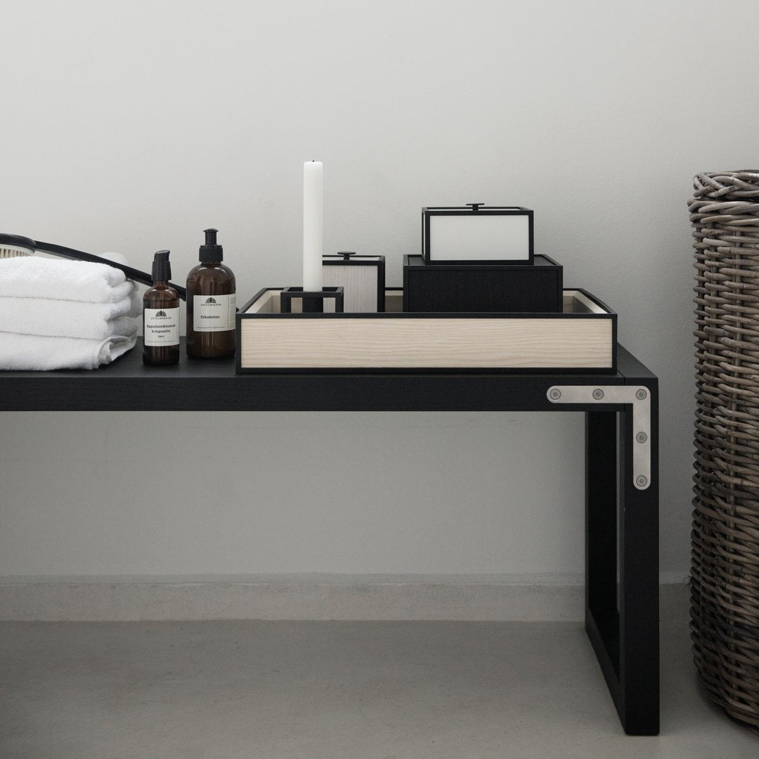 Black and cream decor items on a sleek black table, complemented by a woven basket in natural tones.