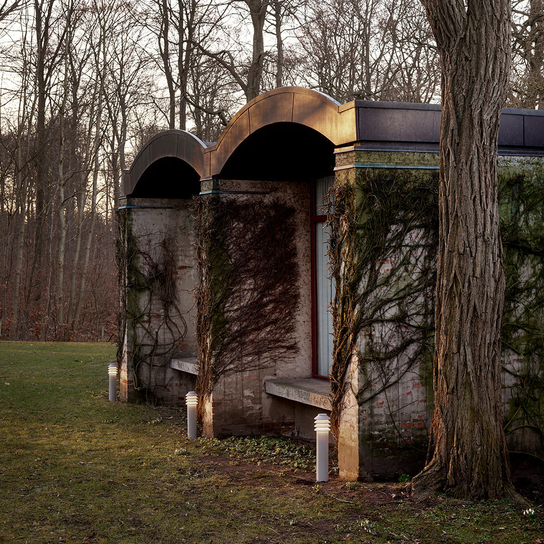 "Elegant gold accents on a rustic stone structure, surrounded by green ivy and soft natural hues."
