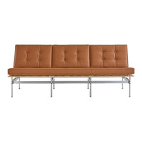 Tan leather sofa with button tufting and sleek chrome legs, featuring a modern, minimalist design.