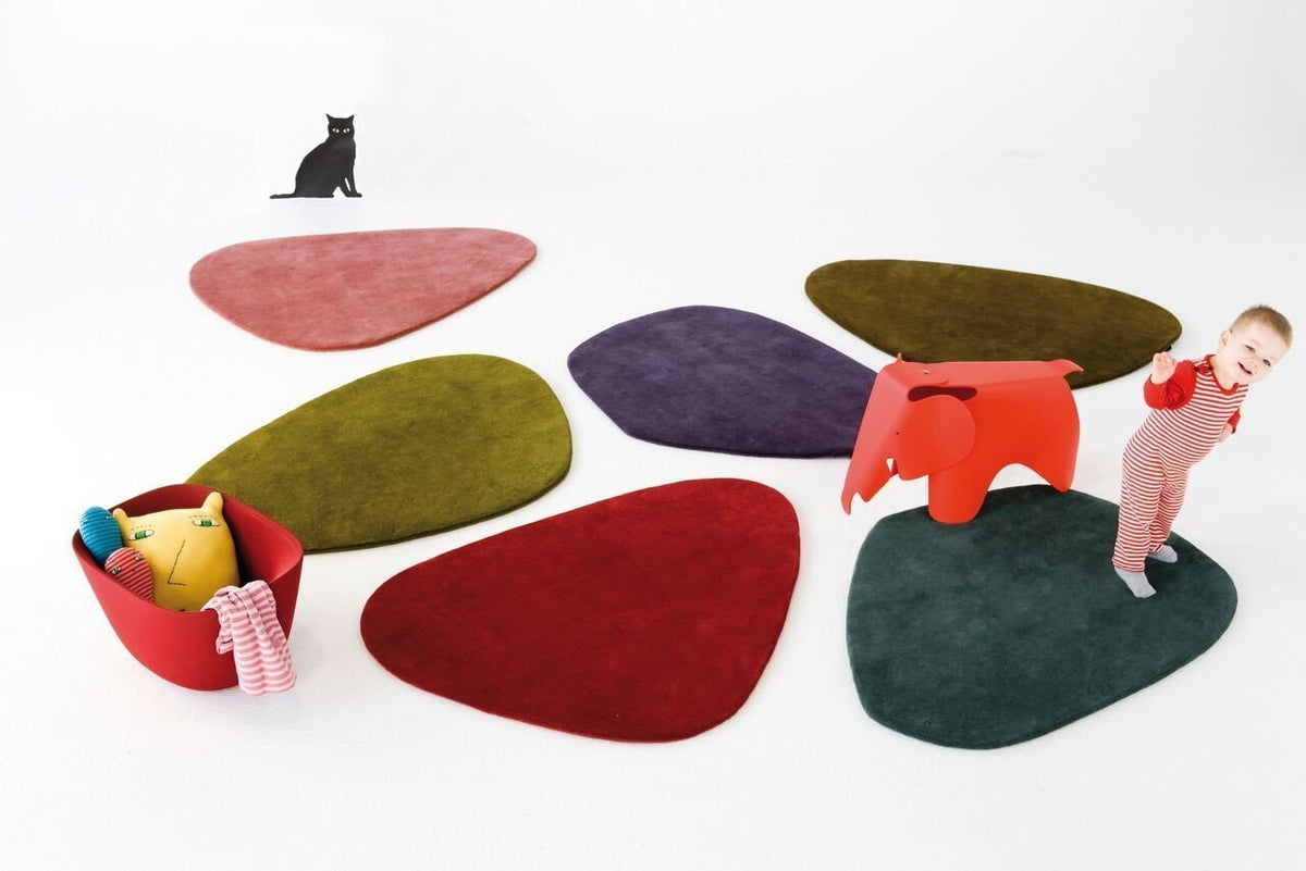 Colorful, organic-shaped rugs in shades of green, burgundy, purple, pink, and brown against a white background.