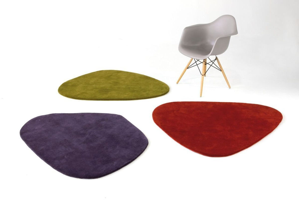 Colorful area rugs in green, purple, and red, featuring unique organic shapes against a minimalist background.