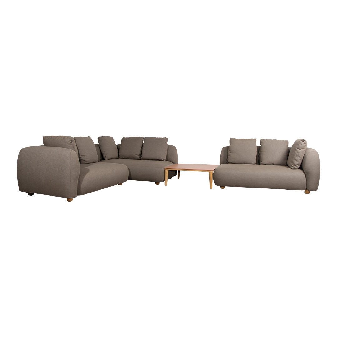 Beige sectional sofa with smooth fabric and subtle textured patterns, accented by plush cushions and wooden legs.