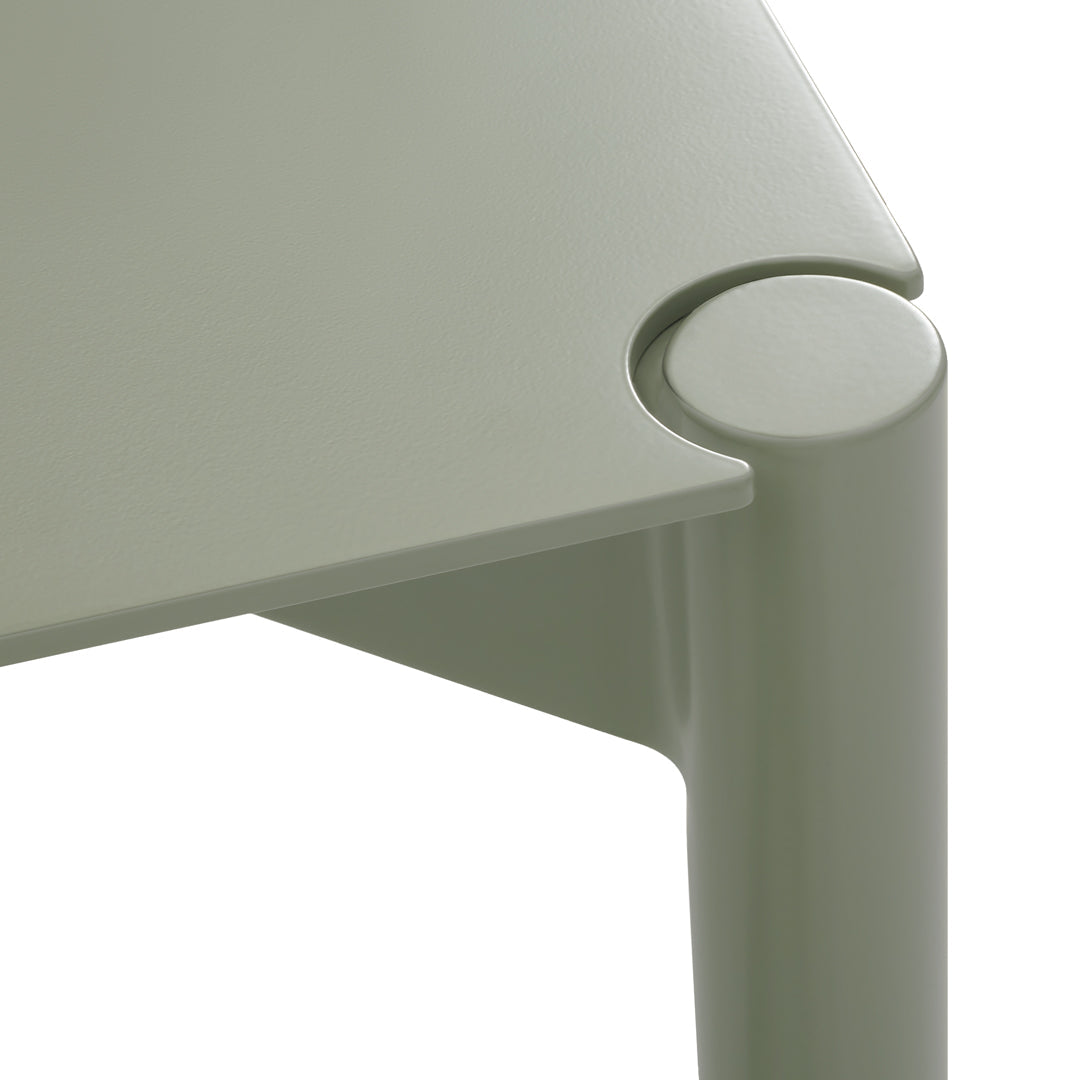 Green table featuring a modern design with smooth curves and a matte finish, perfect for contemporary decor.