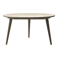 Round wooden table with a light beige surface and contrasting dark brown legs, featuring a sleek, minimalist design.