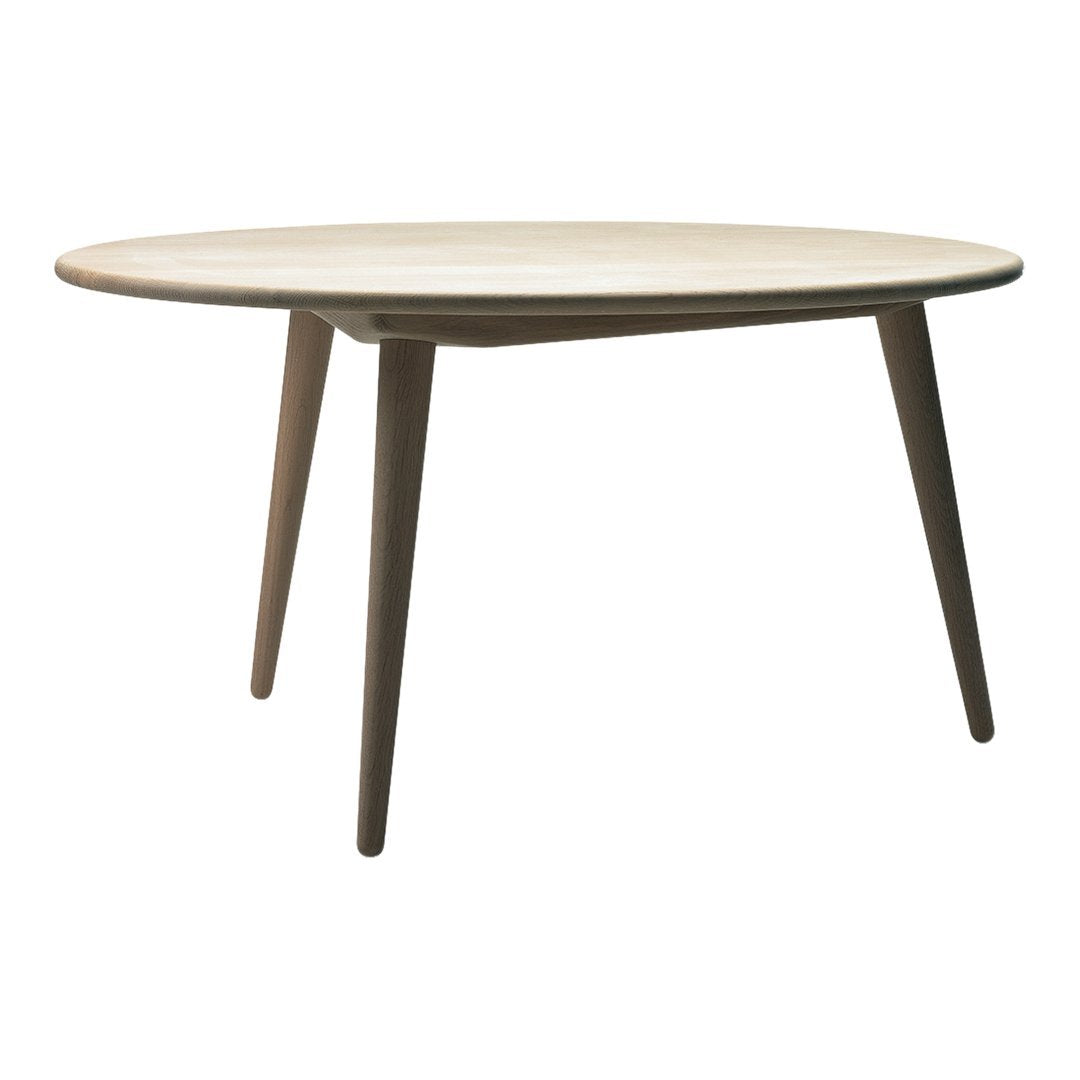 Round wooden table with a light natural finish and dark wooden legs, showcasing a minimalist design.