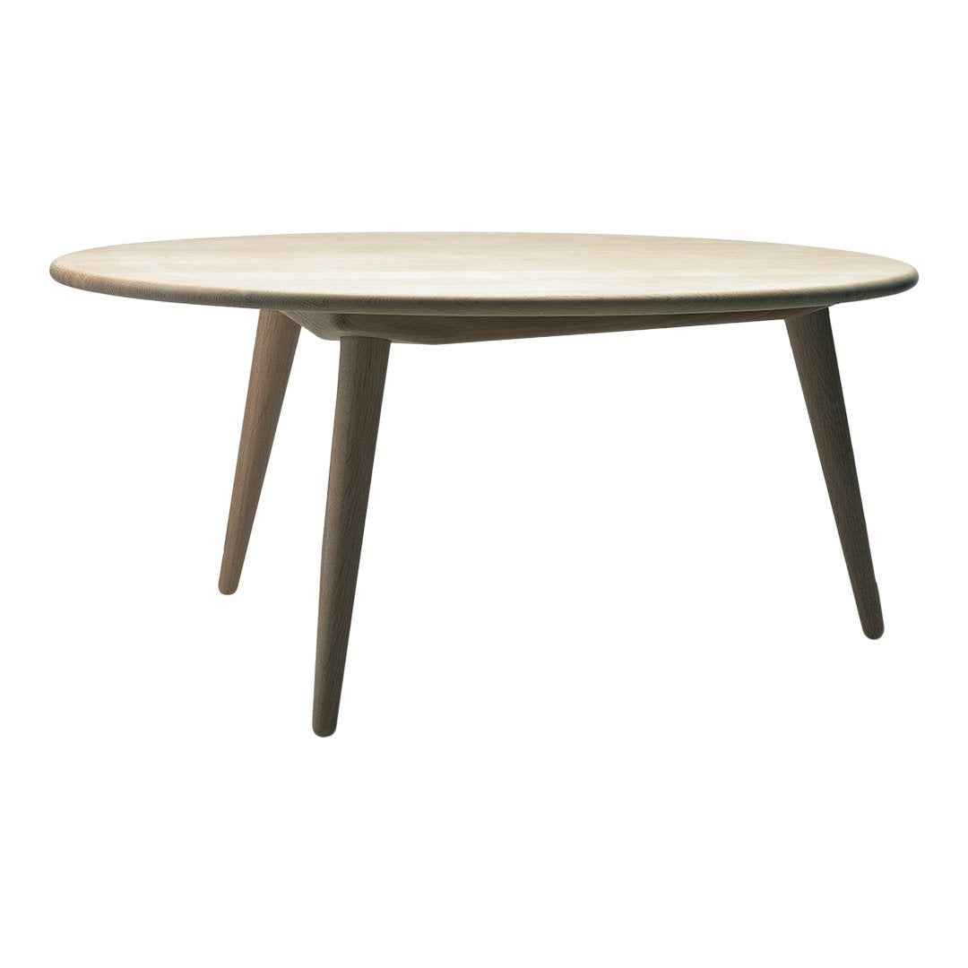 Round wooden table with a light natural finish and tapered brown legs, showcasing a minimalist design.