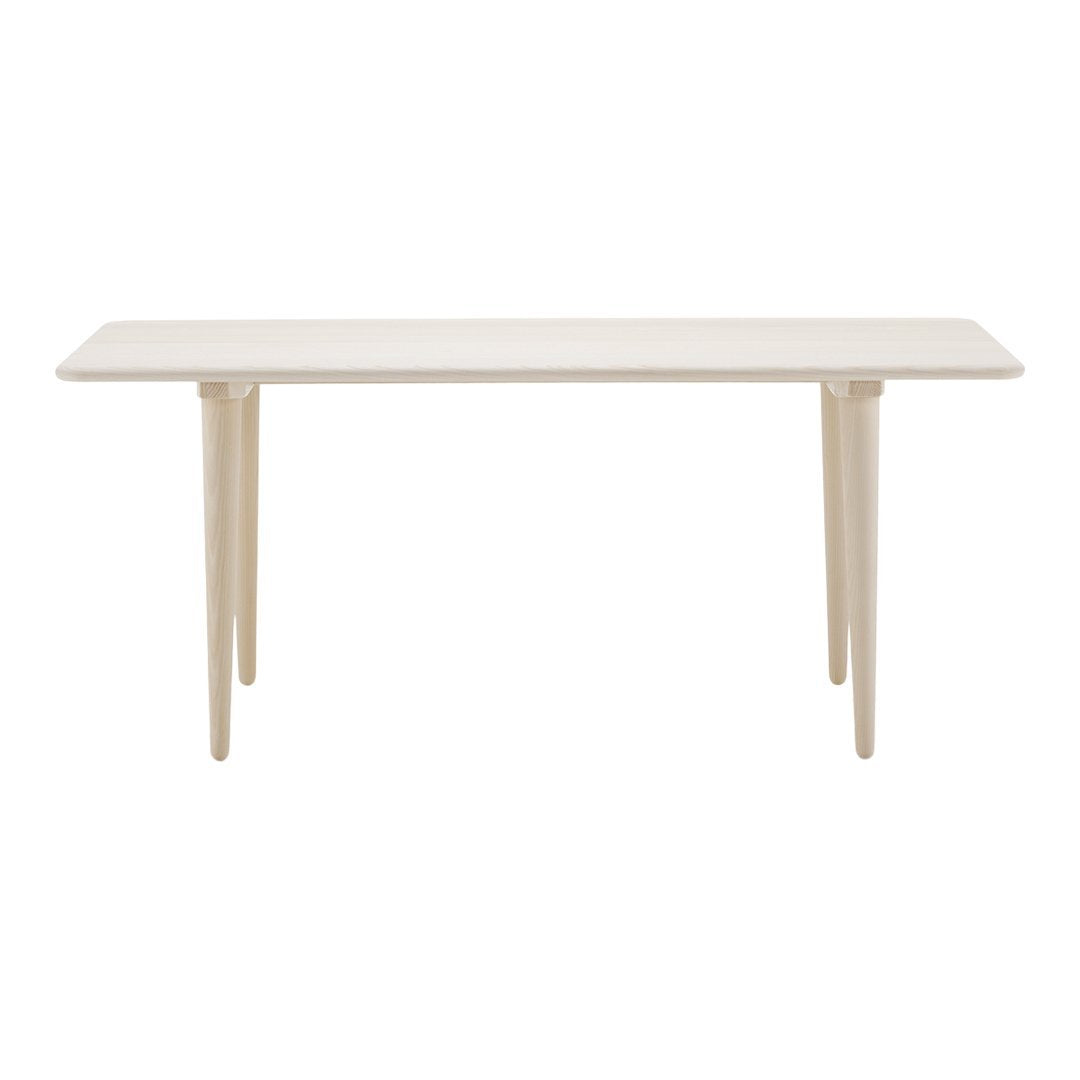 Minimalist rectangular table in soft cream color with natural wood legs, showcasing a sleek, modern design.