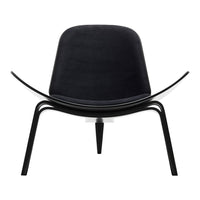 Black designer chair with smooth curves and minimalist black metal legs, showcasing modern elegance.