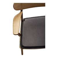 Black seat cushion on a wooden chair, featuring a natural oak finish with smooth, minimalist lines.