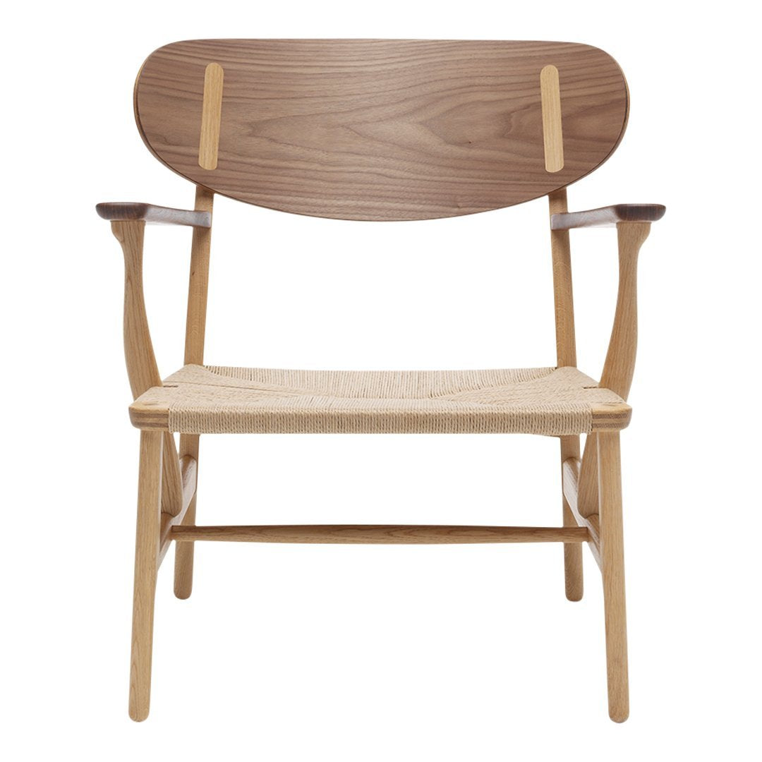 Stylish wooden chair with a walnut back, natural woven seat, and light wooden frame; modern design accentuated by warm tones.