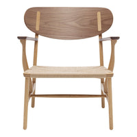 Stylish wooden chair with a walnut back, natural woven seat, and light wooden frame; modern design accentuated by warm tones.