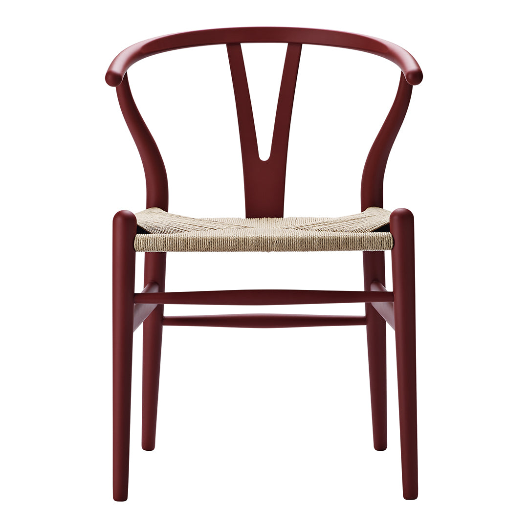 Red wooden chair with a unique Y-shaped back and natural woven seat. Ideal for modern and minimalist decor.