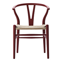 Red wooden chair with a unique Y-shaped back and natural woven seat. Ideal for modern and minimalist decor.