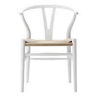 White wooden chair with a natural woven seat, featuring a minimalist design and elegant curves.