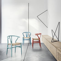 "Colorful chairs in turquoise, red, and natural wood with geometric decor in a modern interior."