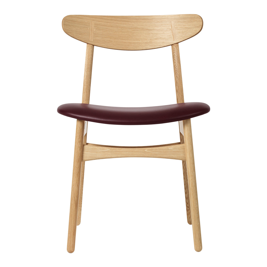 Wooden chair with a natural oak finish and a rich burgundy seat, featuring clean, minimalist lines.