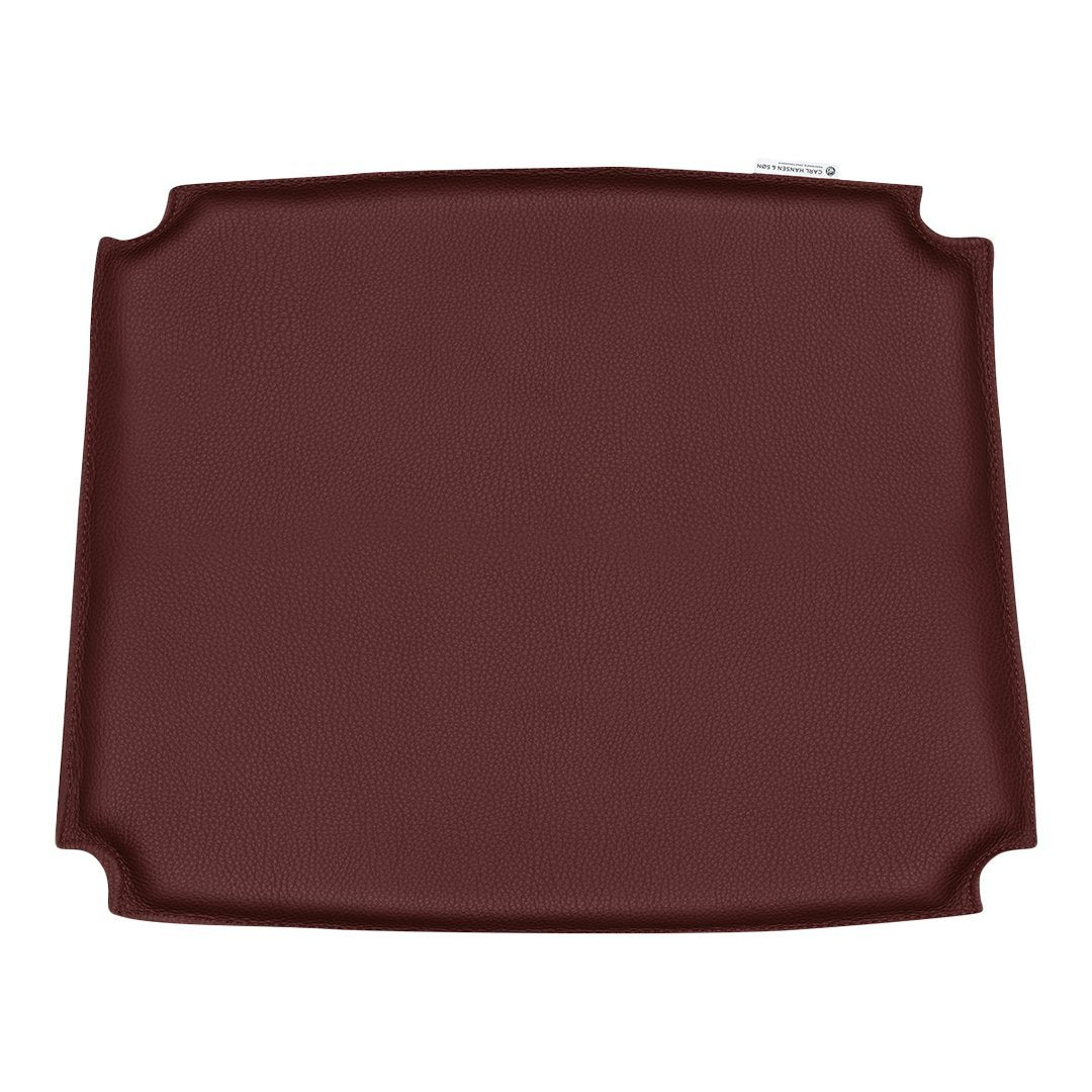 Deep burgundy silicone placemat with a smooth surface and elegant curved edges, ideal for dining settings.