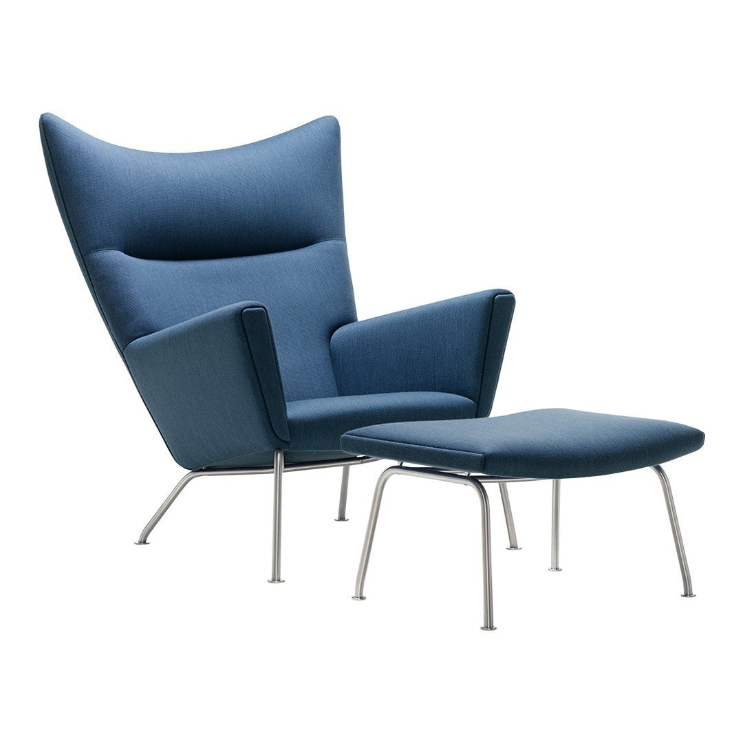 Blue upholstered armchair with matching ottoman, featuring a sleek, minimalist design and smooth, modern lines.