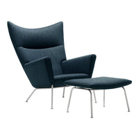 Dark blue fabric armchair with a high back and matching ottoman on sleek chrome legs.