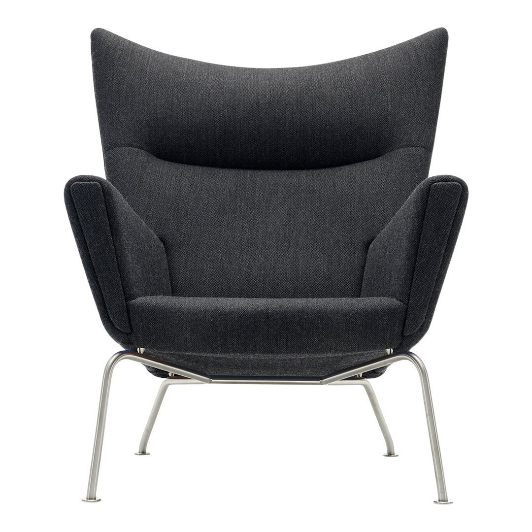 Modern dark gray armchair with a sleek, textured fabric and minimalist silver legs, featuring a stylish wingback design.