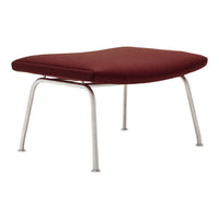 Burdeaux red ottoman with sleek silver legs, featuring a minimalist, modern design.