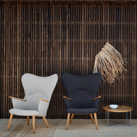 Gray and black armchairs with wooden legs, set against a textured wooden backdrop. Elegant, modern design.