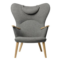 Stylish gray upholstered chair with a unique butterfly shape and natural wood legs. Perfect for modern decor.