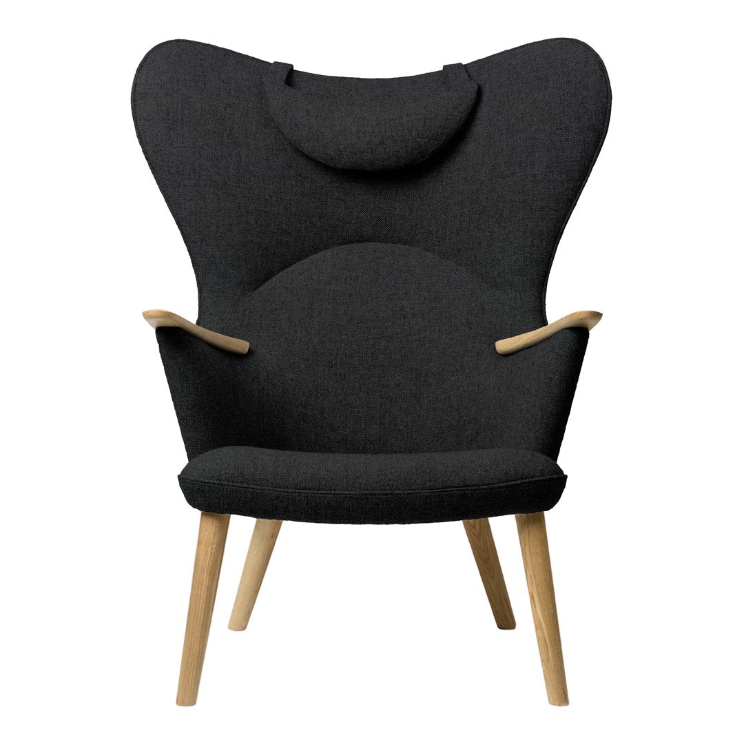 "Stylish black upholstered chair with a unique butterfly shape and wooden legs, perfect for modern decor."