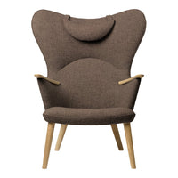 Brown upholstered chair with a smooth texture and wooden legs, featuring a unique wingback design.