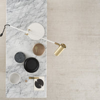 Stylish marble tabletop with various circular accessories in black, gray, white, and gold accents. Elegant modern design.