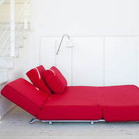 Red adjustable sofa with a sleek design and smooth texture, featuring bold, solid color cushions.