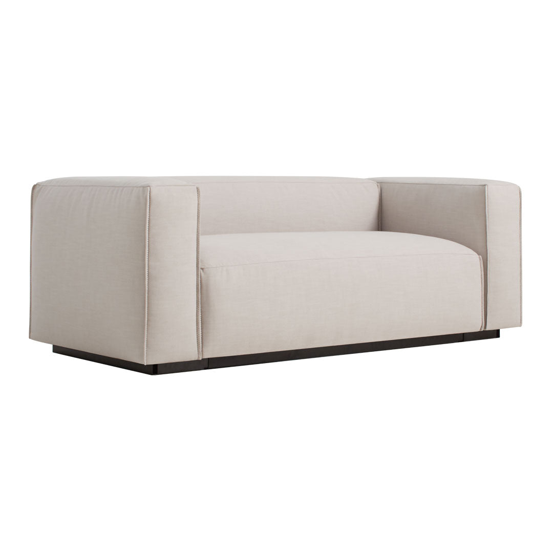 Light beige sofa with a minimalist design and solid dark wood base, perfect for modern interiors.