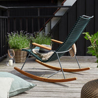 Green and beige rocking chair with elegant wooden accents and distinctive woven pattern, set against a natural backdrop.