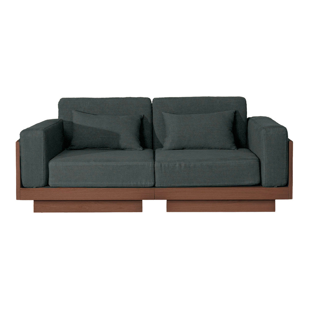 Dark gray upholstered sofa with clean lines and a contrasting brown wooden base, accented by two matching cushions.