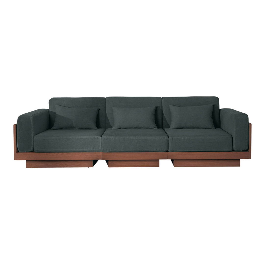 Modern three-seat sofa in dark green fabric with a contrasting earthy brown wood base. Clean lines and minimalist design.