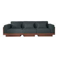 Modern three-seat sofa in dark green fabric with a contrasting earthy brown wood base. Clean lines and minimalist design.