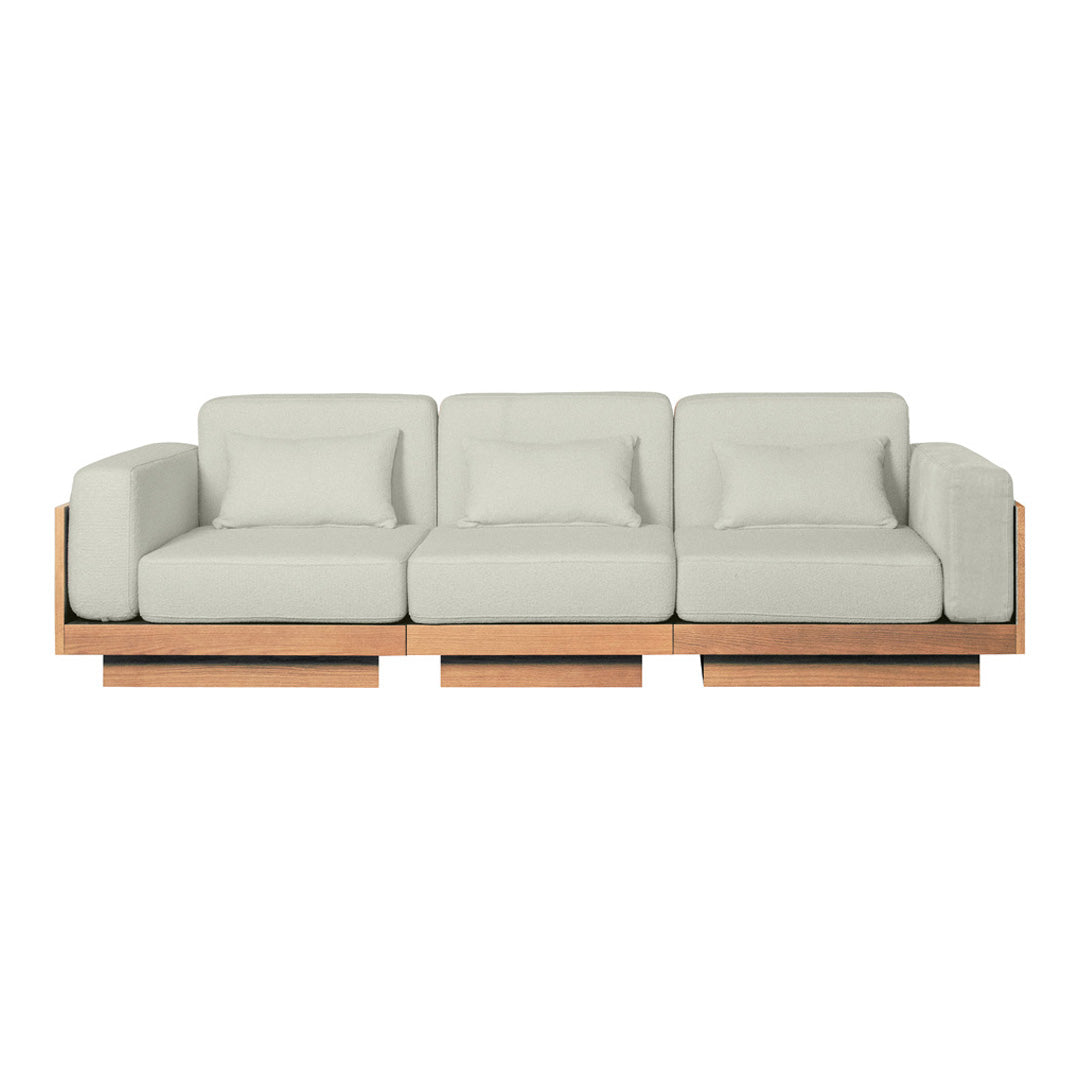 Light gray cushioned sofa with a minimalist wooden base. Modern design with clean lines and neutral tones.