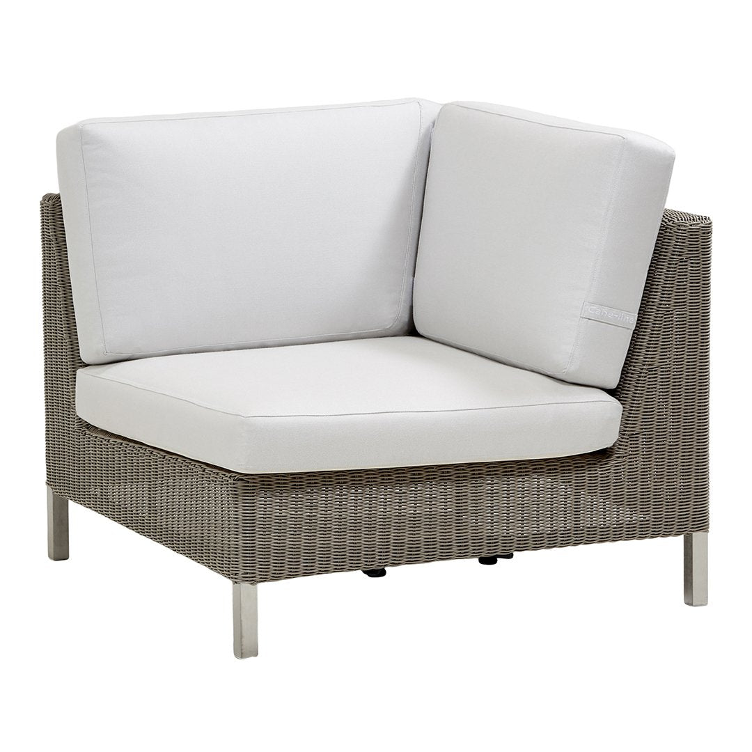 Gray woven rattan corner chair with soft white cushions, perfect for modern outdoor or indoor settings.