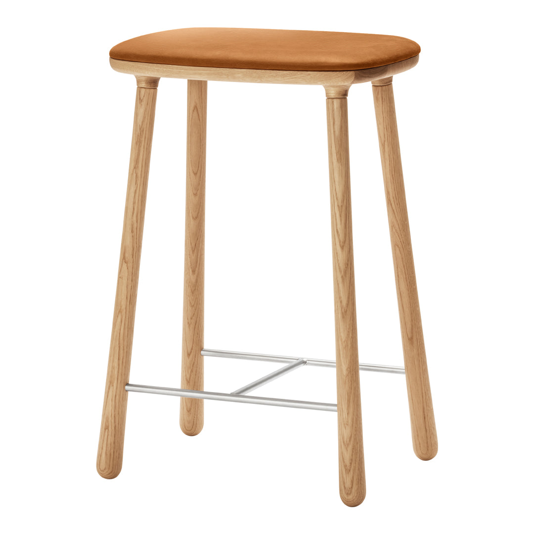 Tan padded seat with natural wood legs and metallic footrest, showcasing a minimalist, modern design.