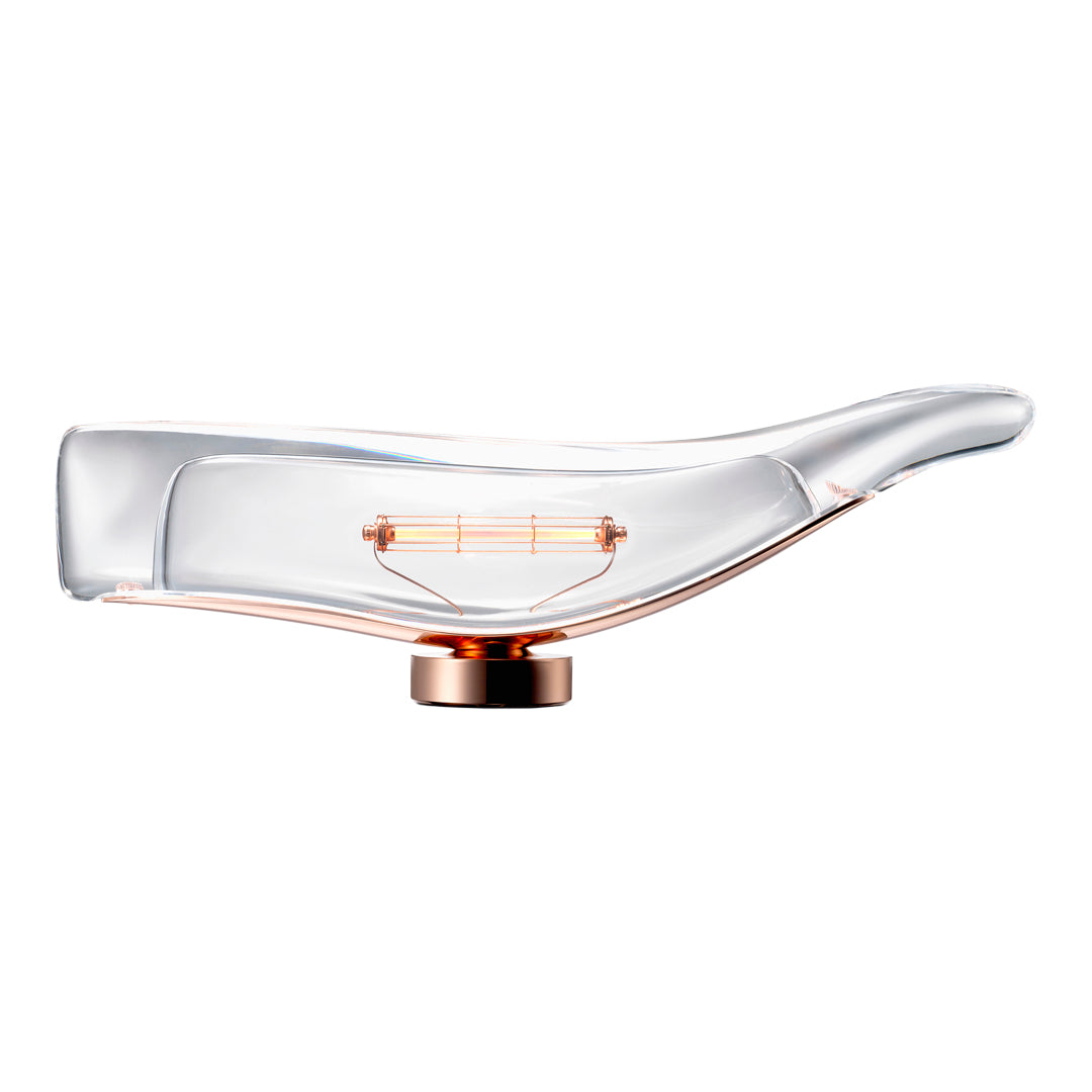 Clear glass lamp with a chic curved design; features a copper base and warm amber filament. Elegant modern aesthetic.