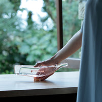 Glass serving dish with a clear body and rose gold base, featuring a sleek, modern design.