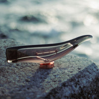 Translucent brown and copper color combination with a sleek, modern design against a blurred ocean backdrop.